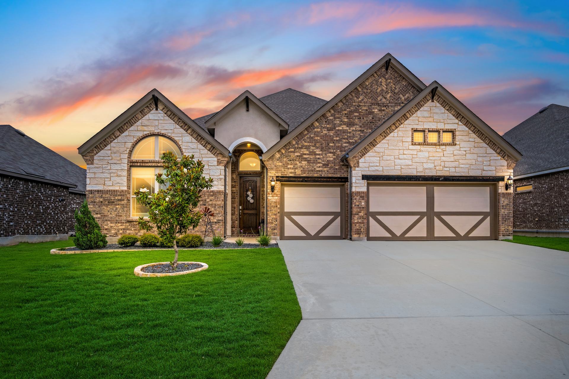 Single-story brick and stone home at dusk in a Fort Bend County, Texas neighborhood