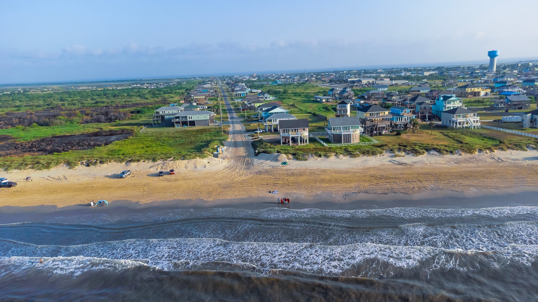 Beach access road running down to the sand between elevated beach homes on Galveston West End