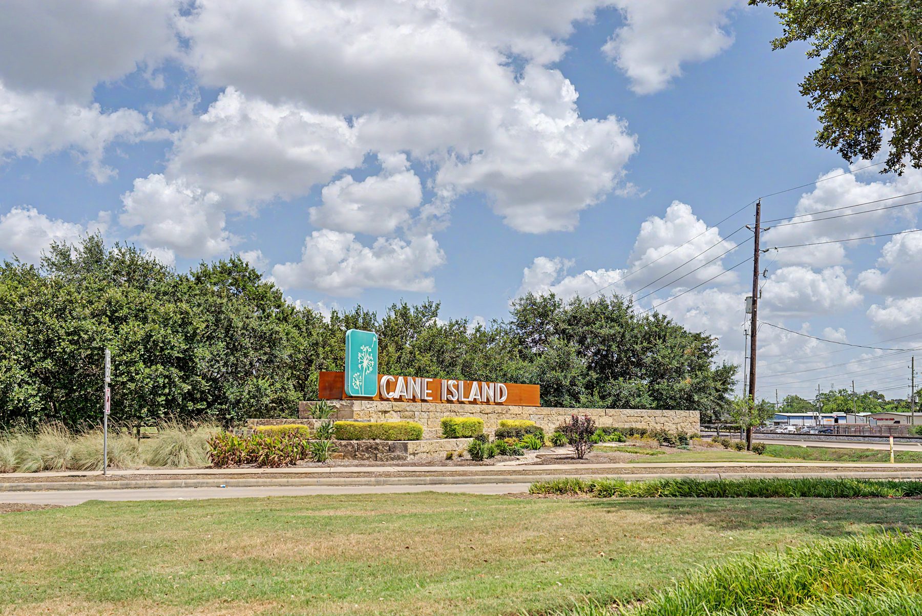 Lakes of Cane Island now open builder sign beside the community entrance monument in Katy