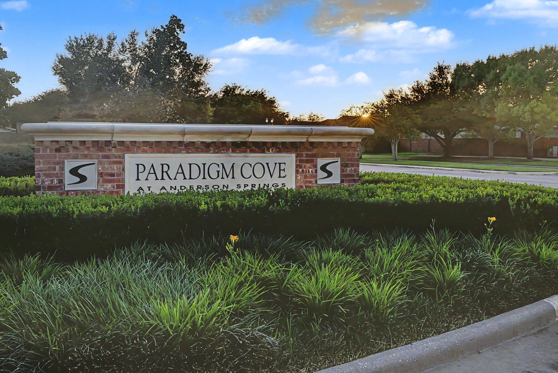 Brick entrance monument for Paradigm Cove at Anderson Springs in Sienna, Missouri City TX, at sunset
